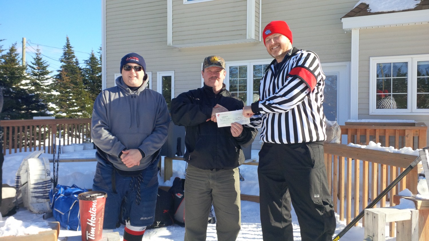 SJFFA President Doug Cadigan and Shane Gamberg  present a check to Todd Churchill of reasonfortherink.com